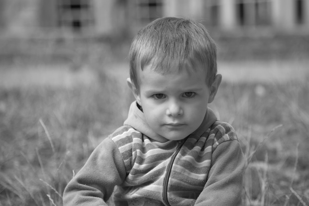 grayscale photo of boy in striped shirt
