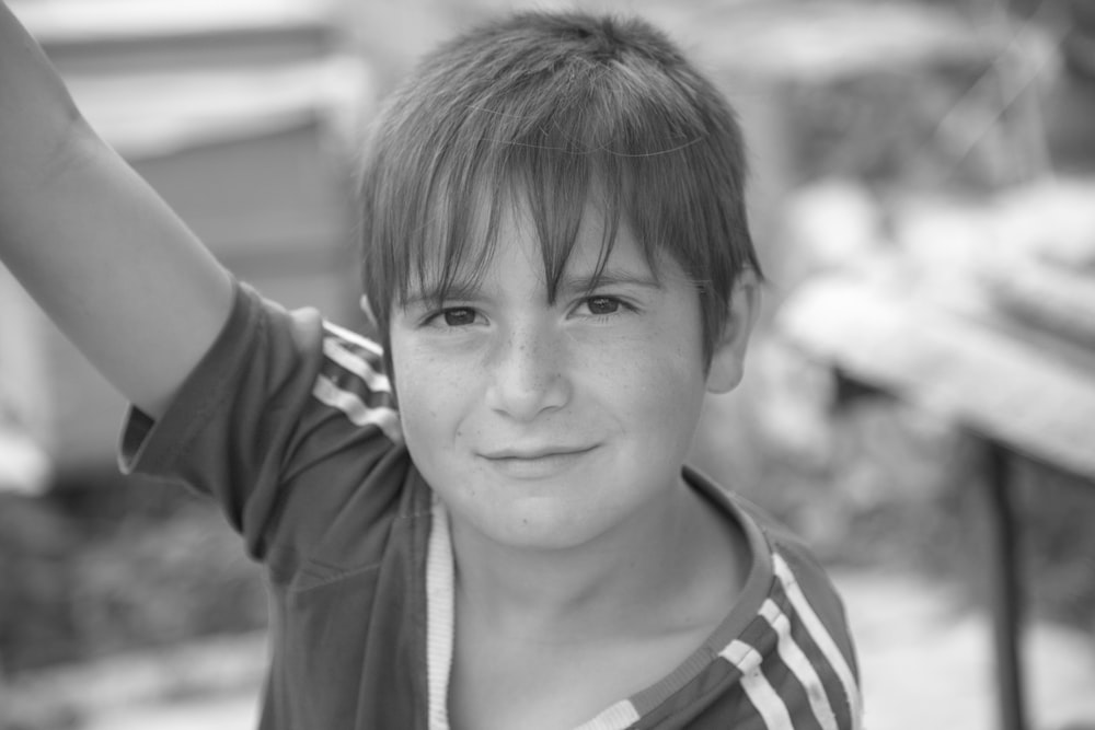 grayscale photo of smiling boy in zip up hoodie