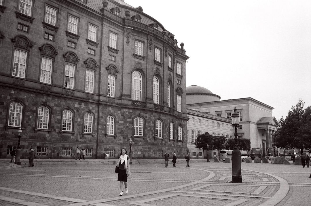 grayscale photo of people walking on street near building