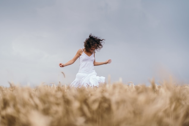 a woman in a white dress running through a field