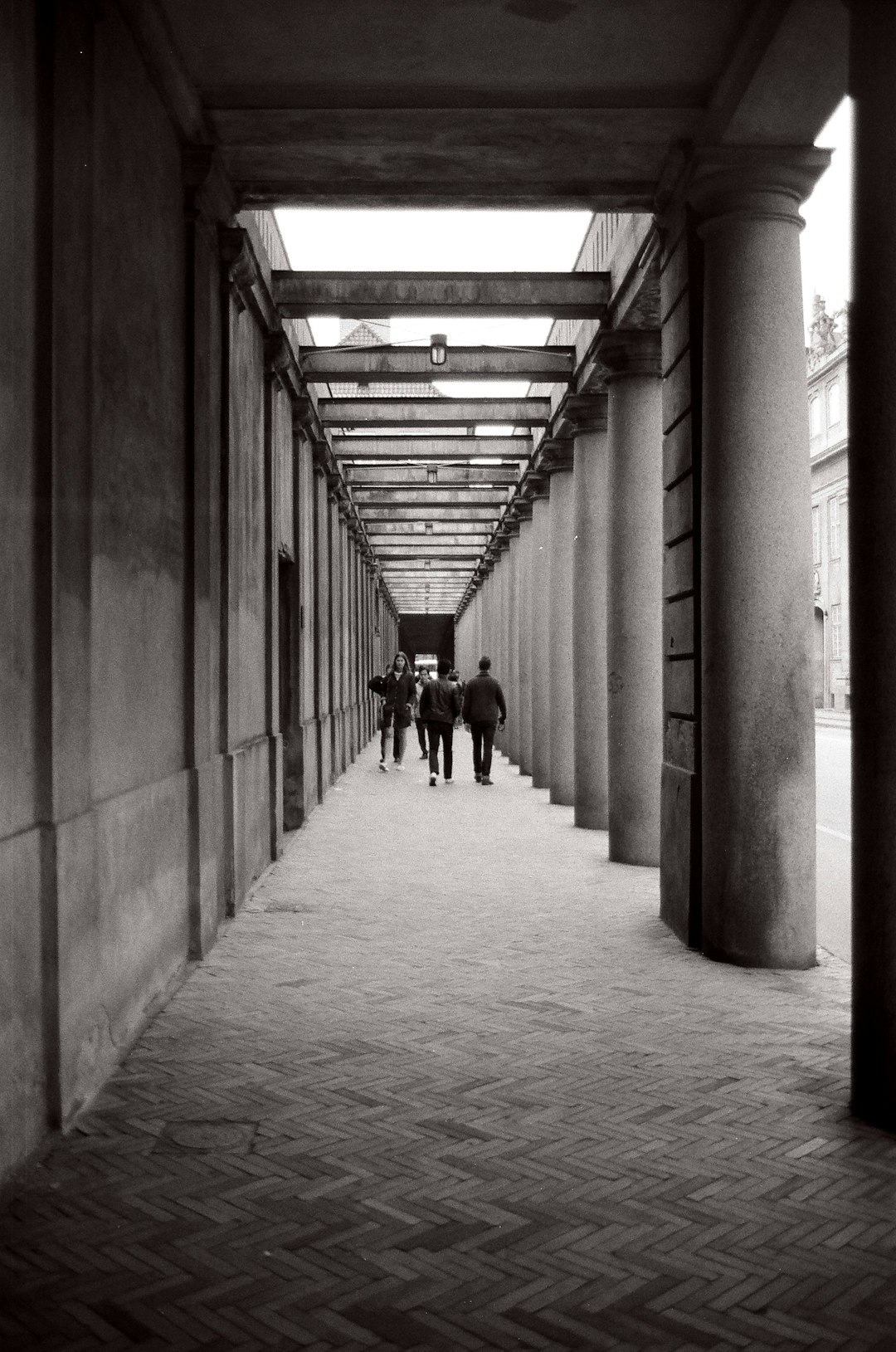 grayscale photo of 2 person walking on hallway