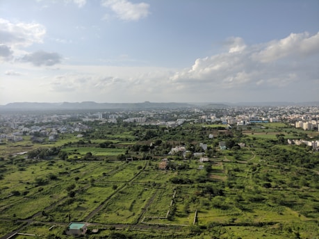A sprawling aerial view of varied land parcels including industrial and residential plots under clear skies