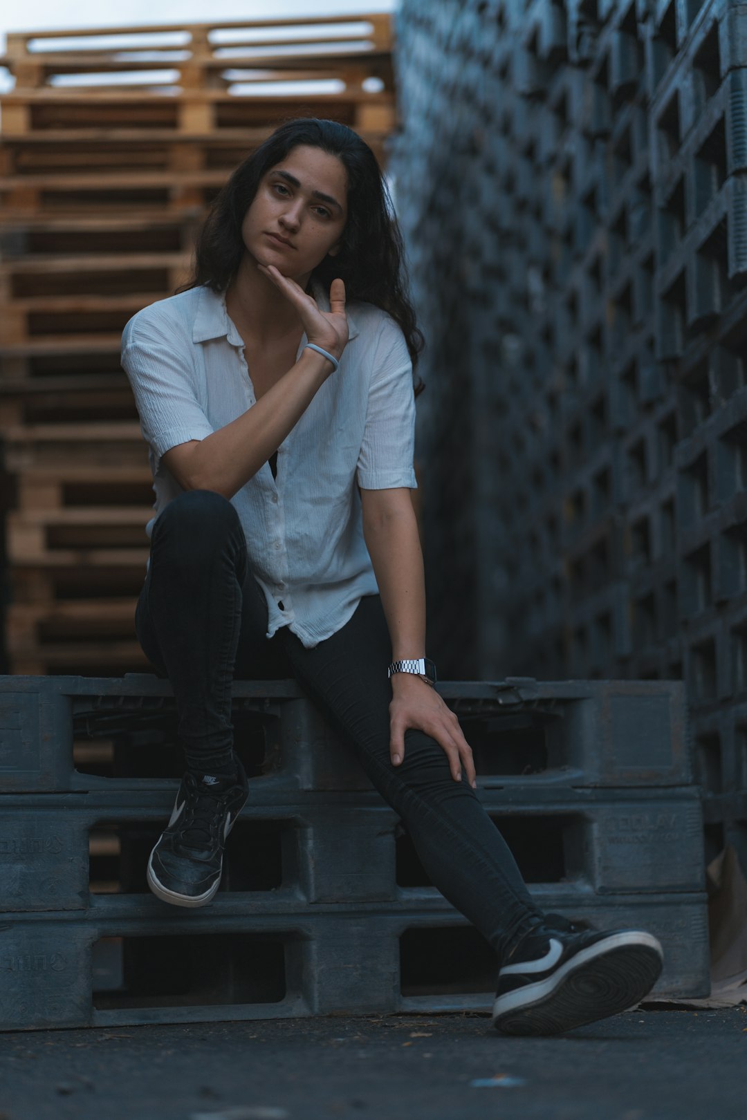 woman in white t-shirt and black pants sitting on gray concrete stairs