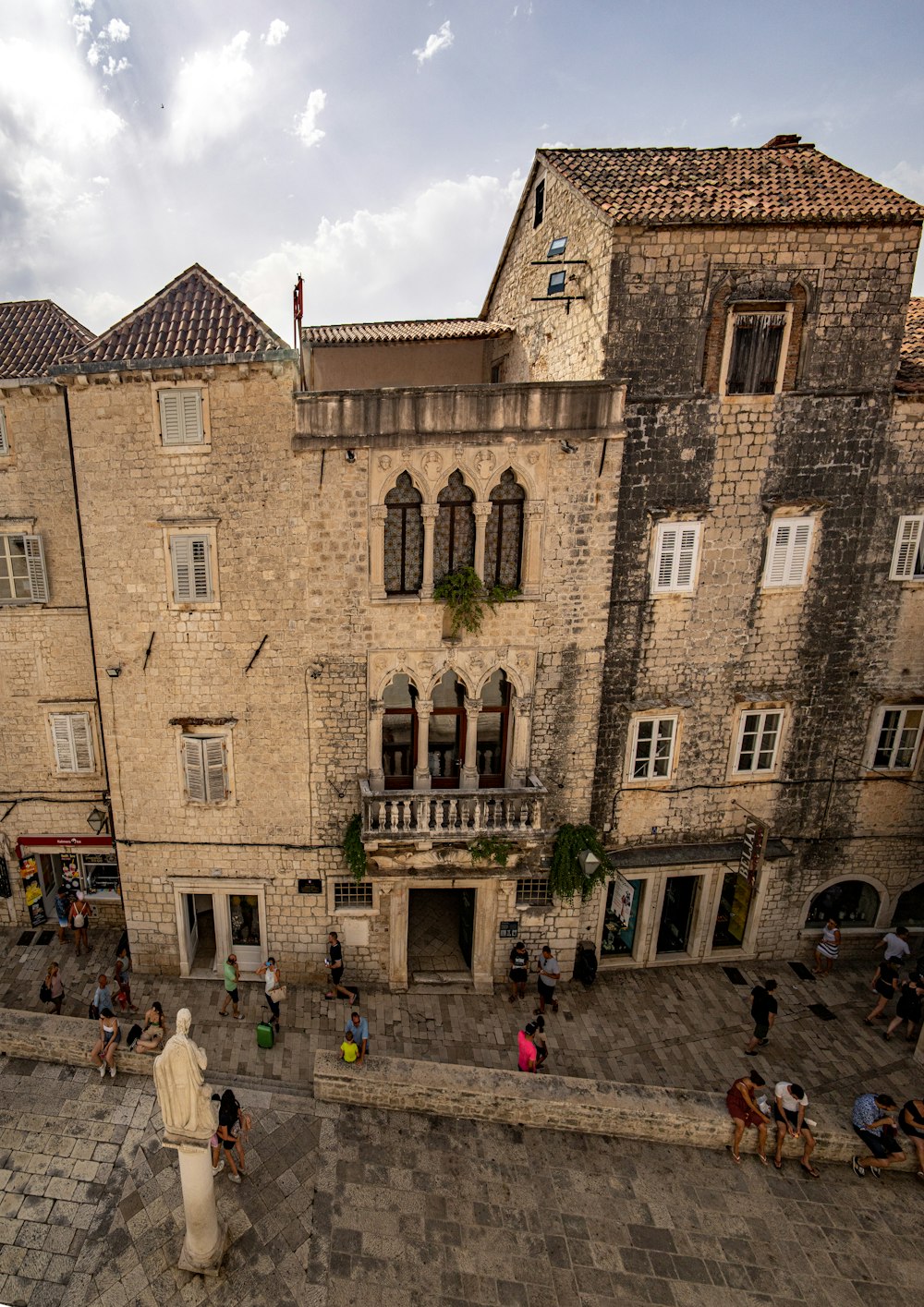 pessoas andando na rua perto de edifício de concreto marrom durante o dia