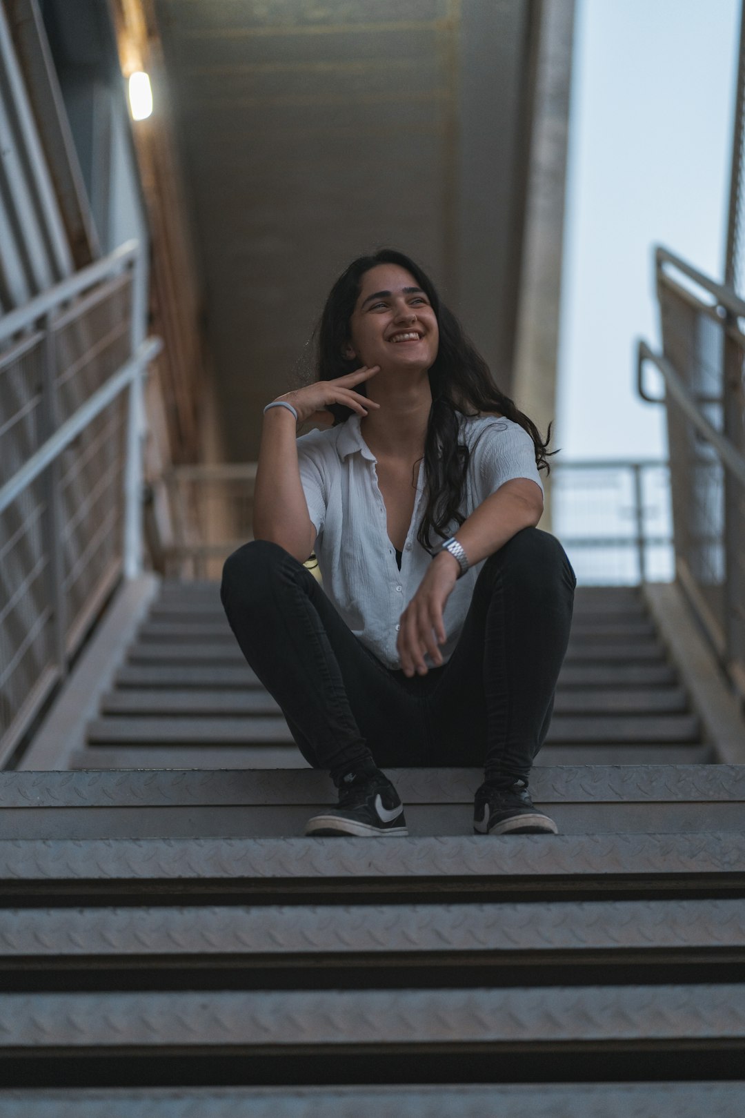 woman in blue denim jacket and black pants sitting on stairs