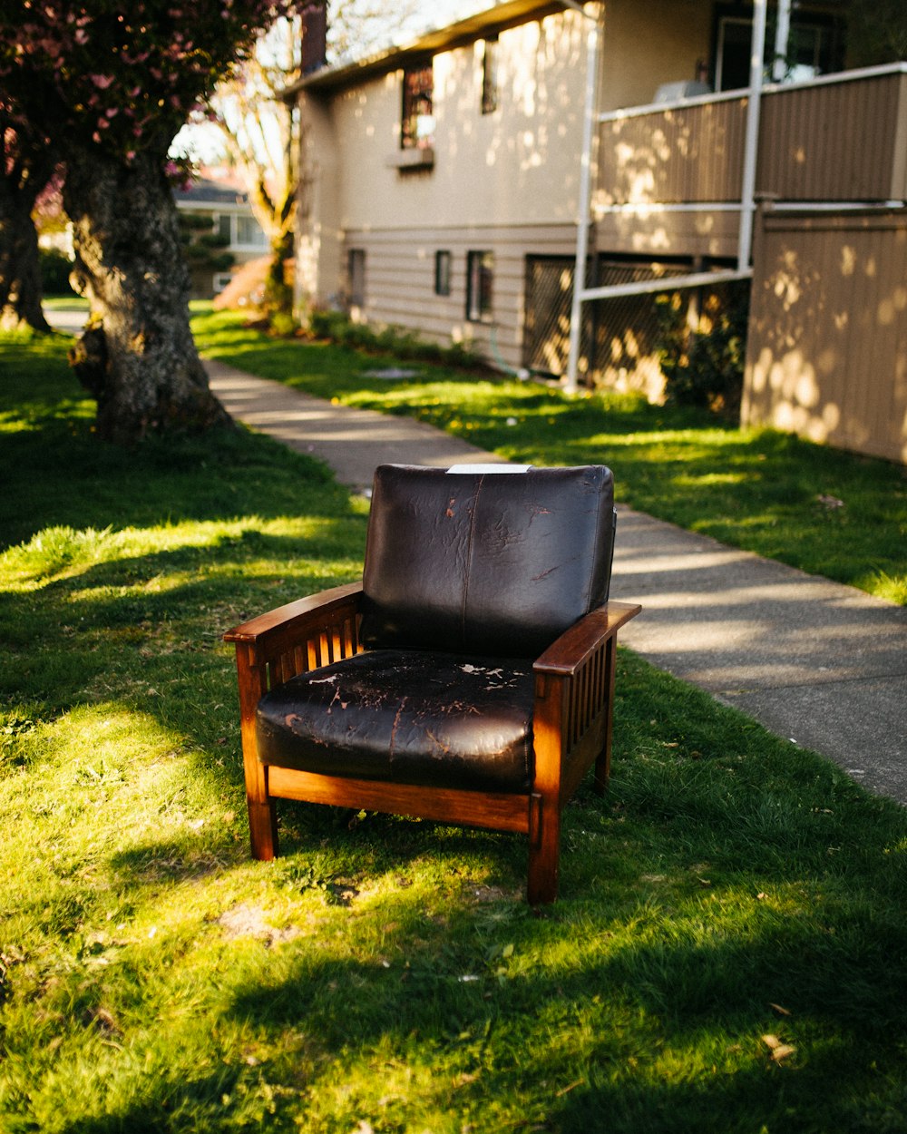 brown wooden armchair on green grass field