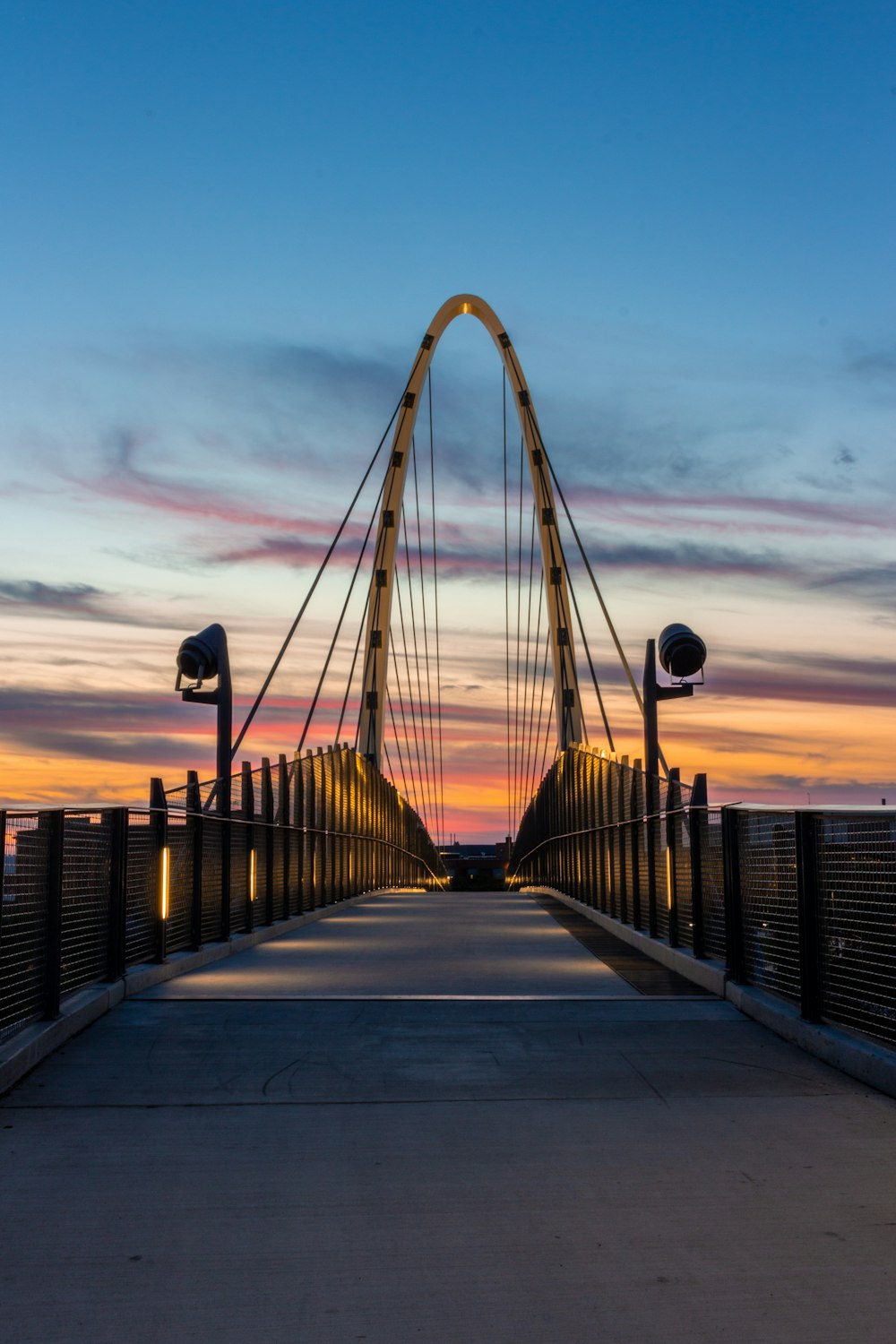 people walking on bridge during sunset