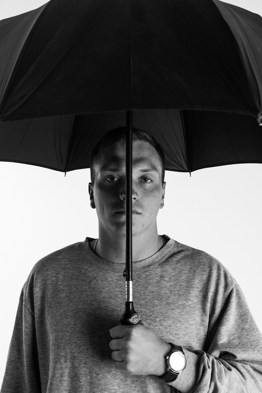 man in black crew neck shirt holding umbrella