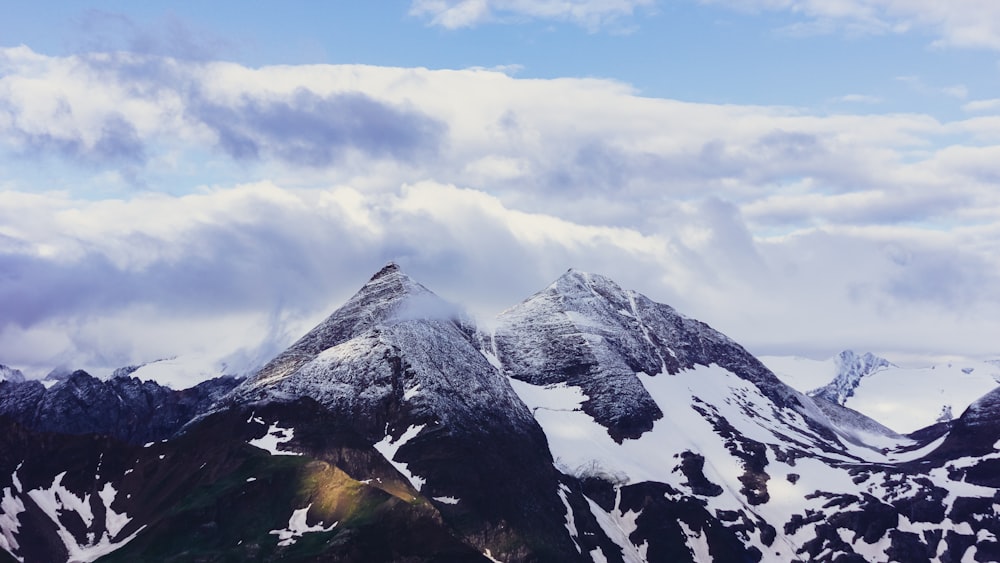 snow covered mountain under cloudy sky during daytime