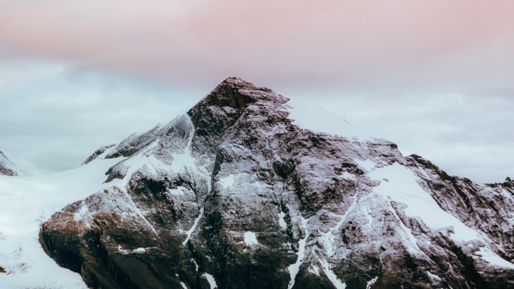 snow covered mountain under cloudy sky during daytime