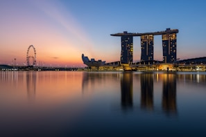 Singapore’s futuristic Marina Bay Sands hotel reflected in the calm waters of the bay at dusk