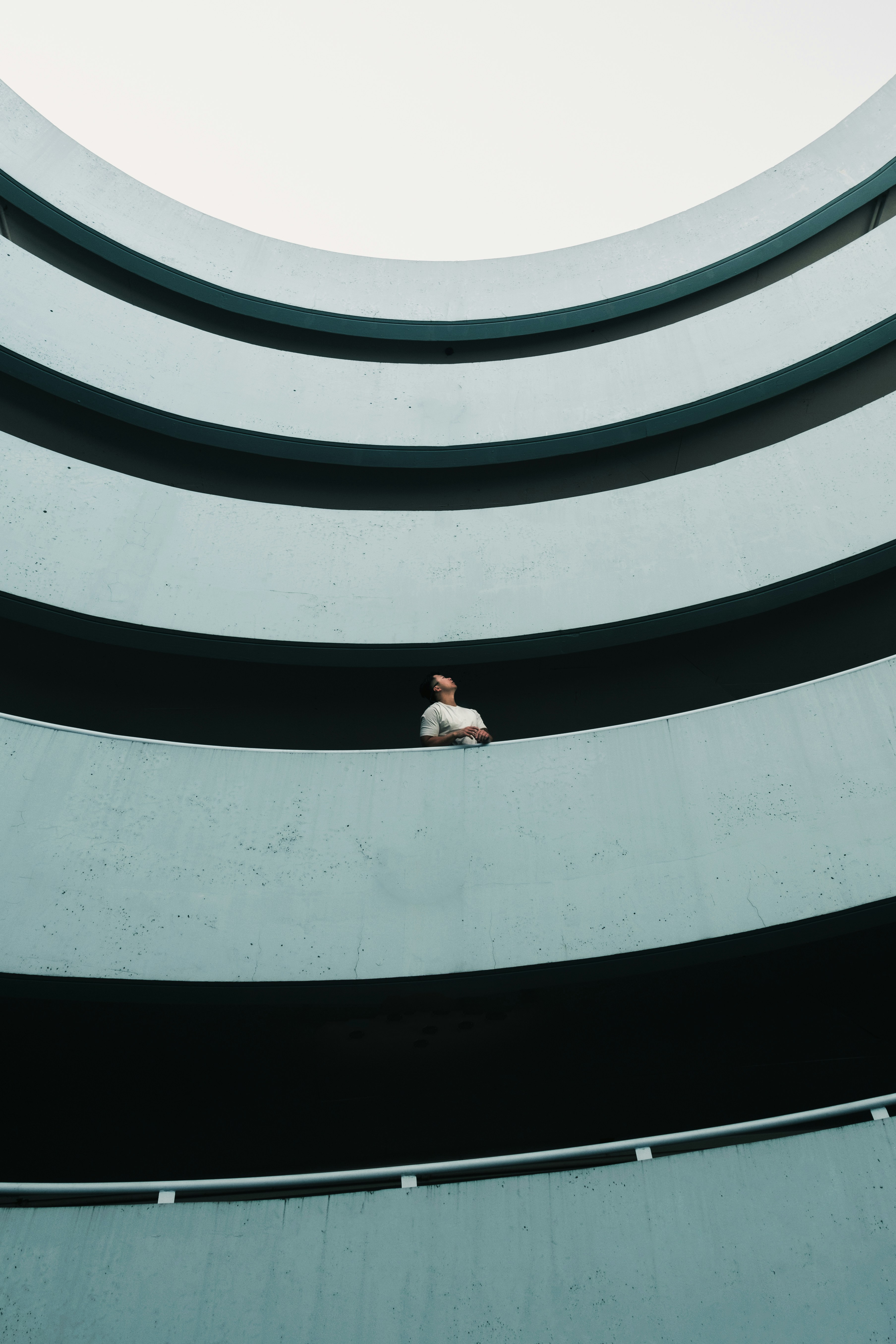 woman in white shirt and black pants standing on white concrete building