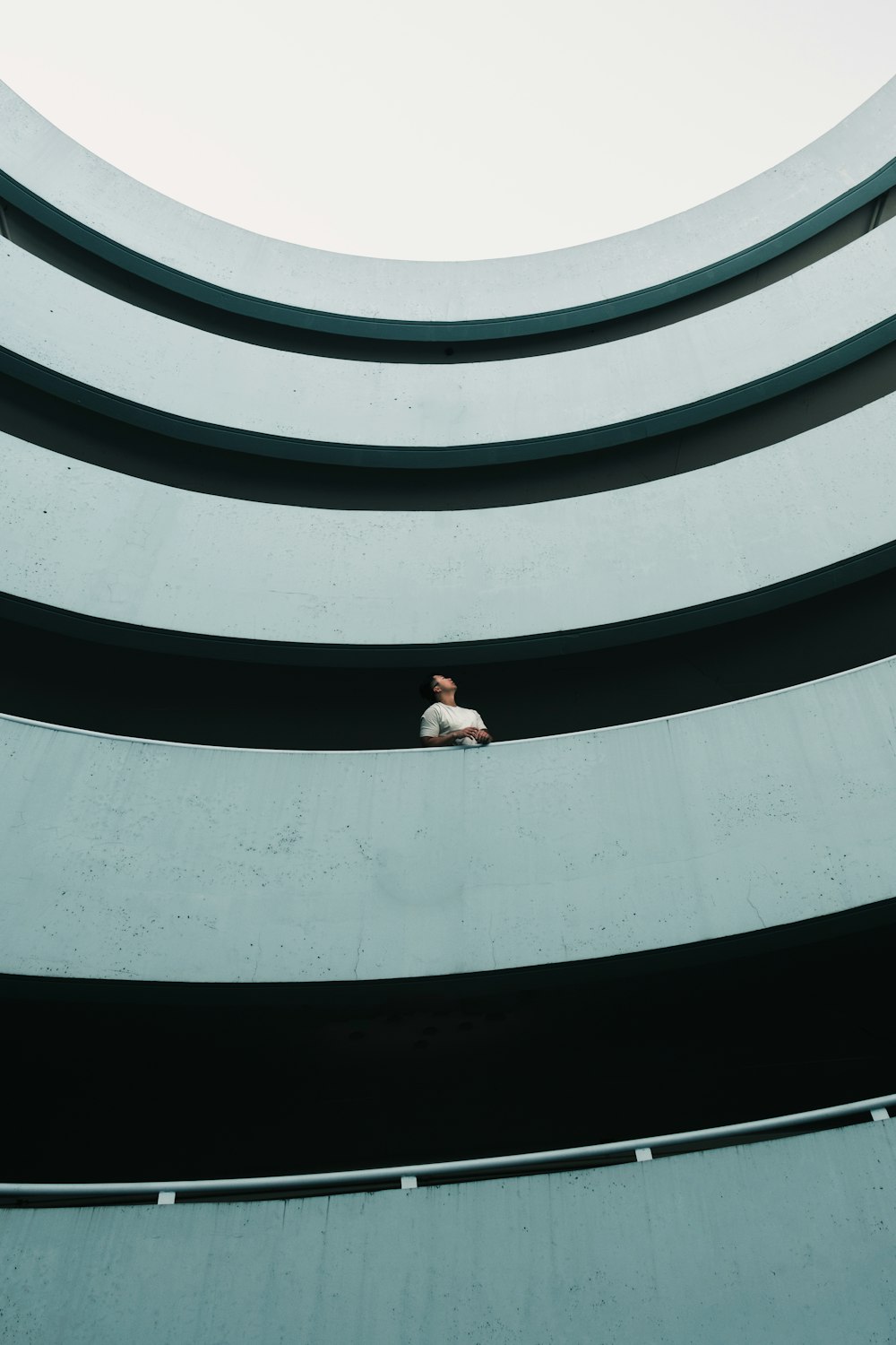 woman in white shirt and black pants standing on white concrete building