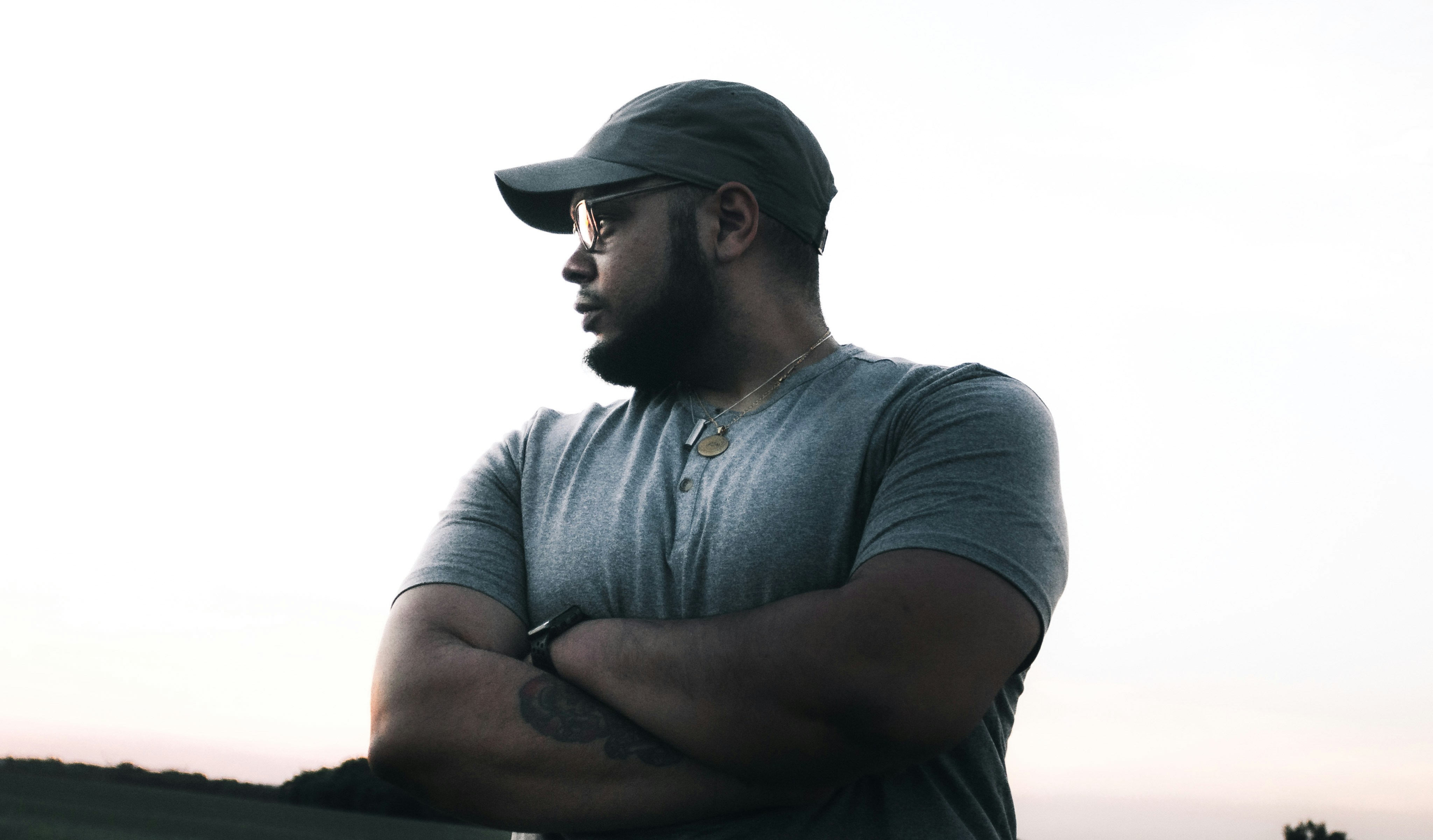 man in gray henley shirt wearing black cap
