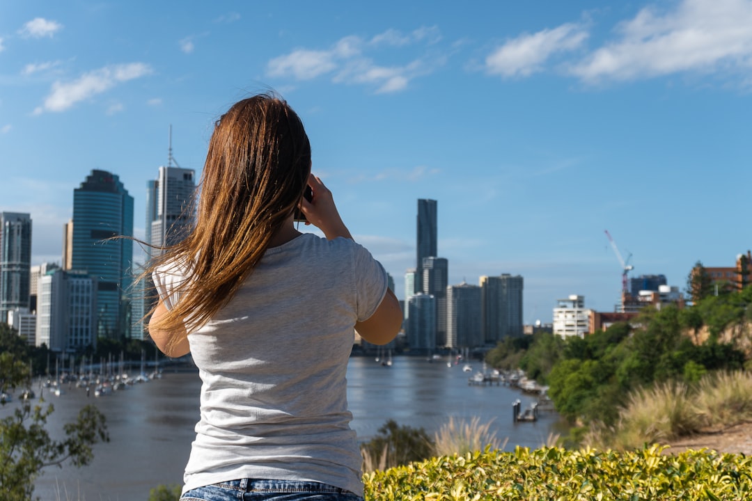 woman in white shirt standing near body of water during daytime