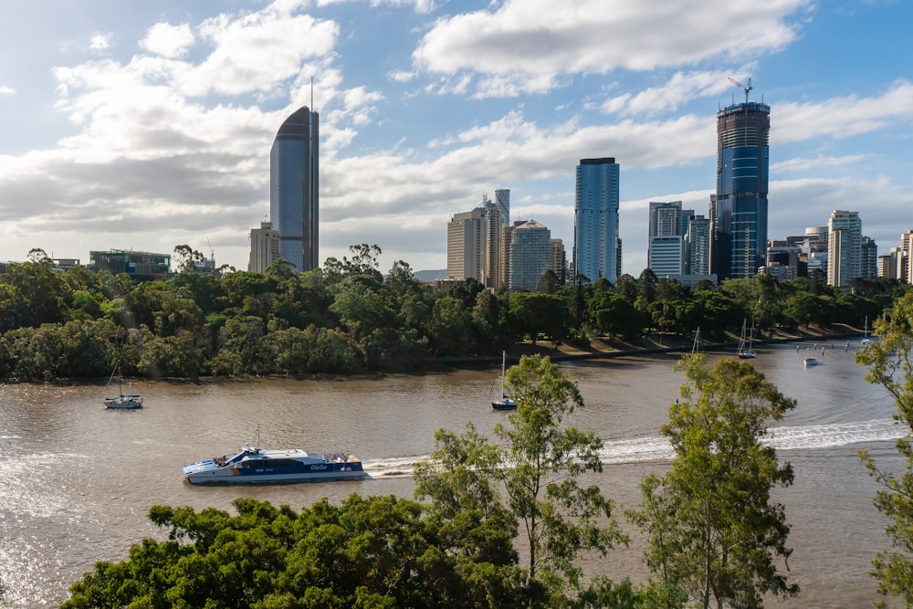 barco branco na água perto de edifícios da cidade durante o dia