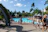 Family enjoying a sunny afternoon at a community park with a swimming pool and sports courts.