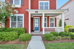 red and white house with green grass lawn