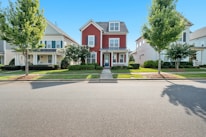 white and brown concrete house near green trees under blue sky during daytime