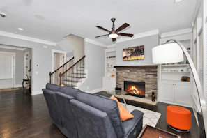 black flat screen tv turned on near gray sofa