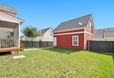 red and white wooden house on green grass field during daytime