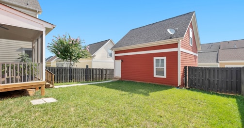 red and white wooden house on green grass field during daytime