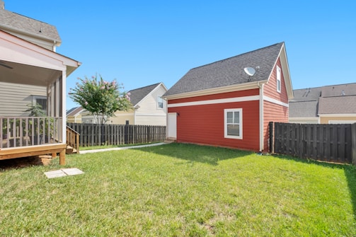 red and white wooden house on green grass field during daytime