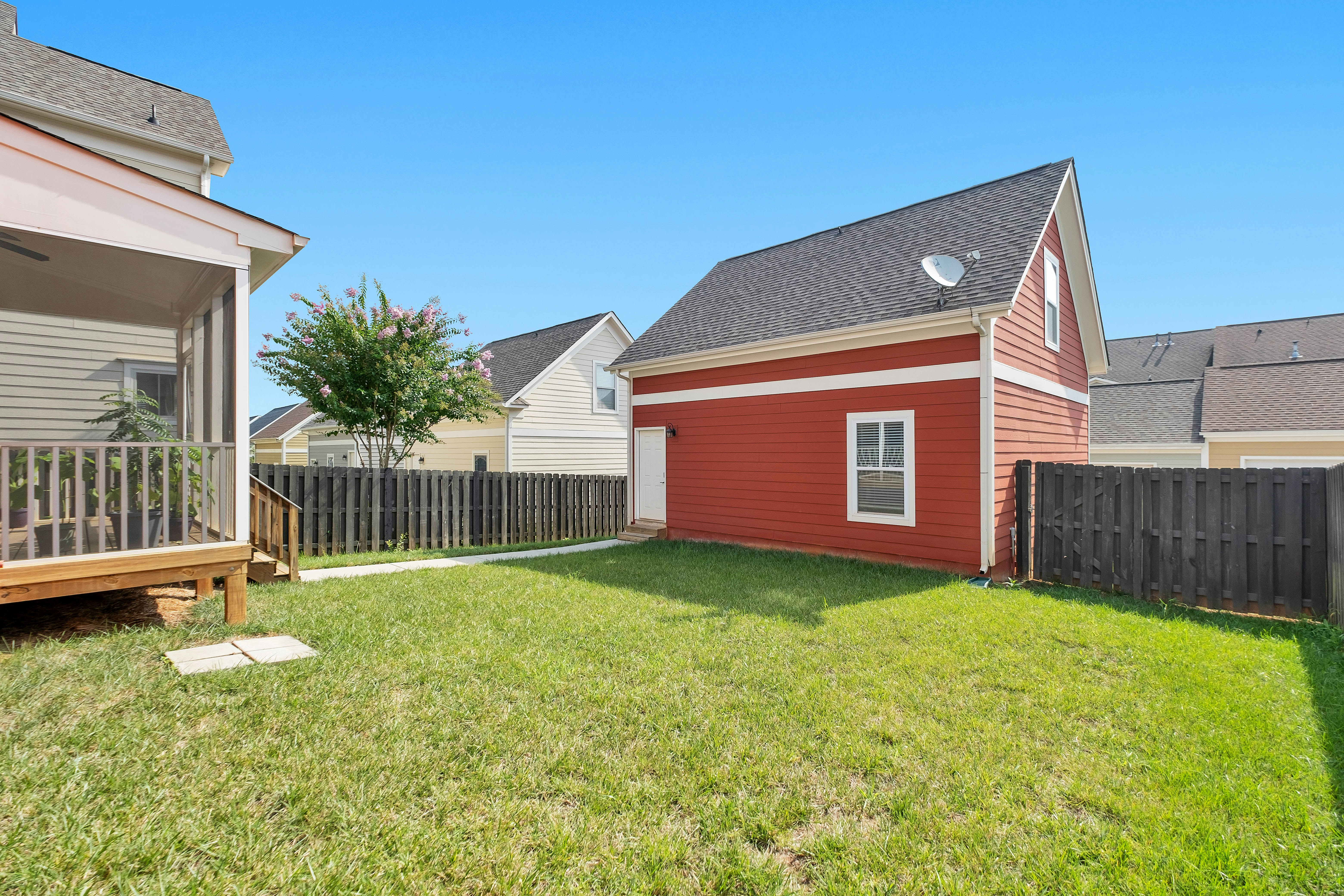 red and white wooden house on green grass field during daytime