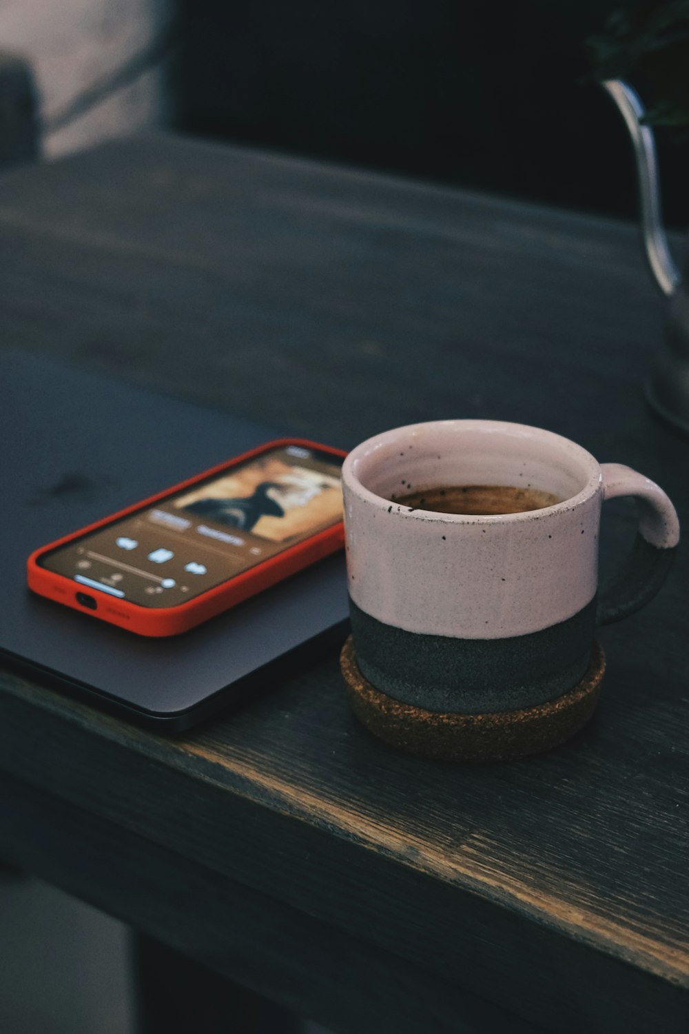 white and black ceramic mug on black wooden table