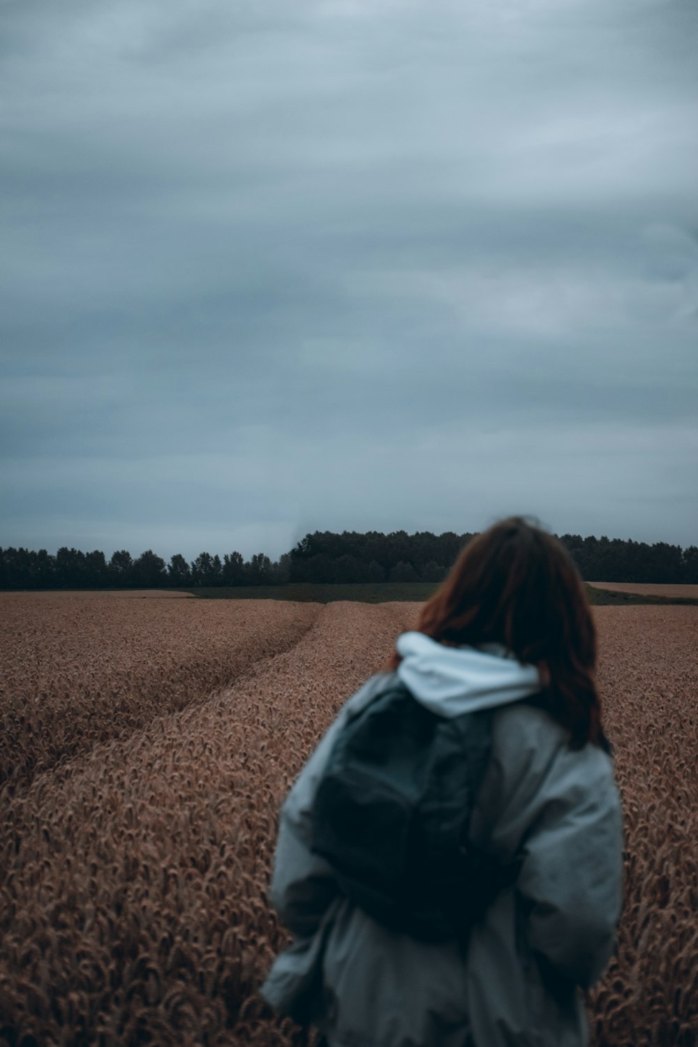 mulher na jaqueta preta em pé no campo marrom durante o dia
