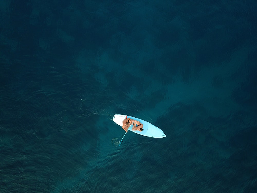 昼間、青い海でサーフィンをする人