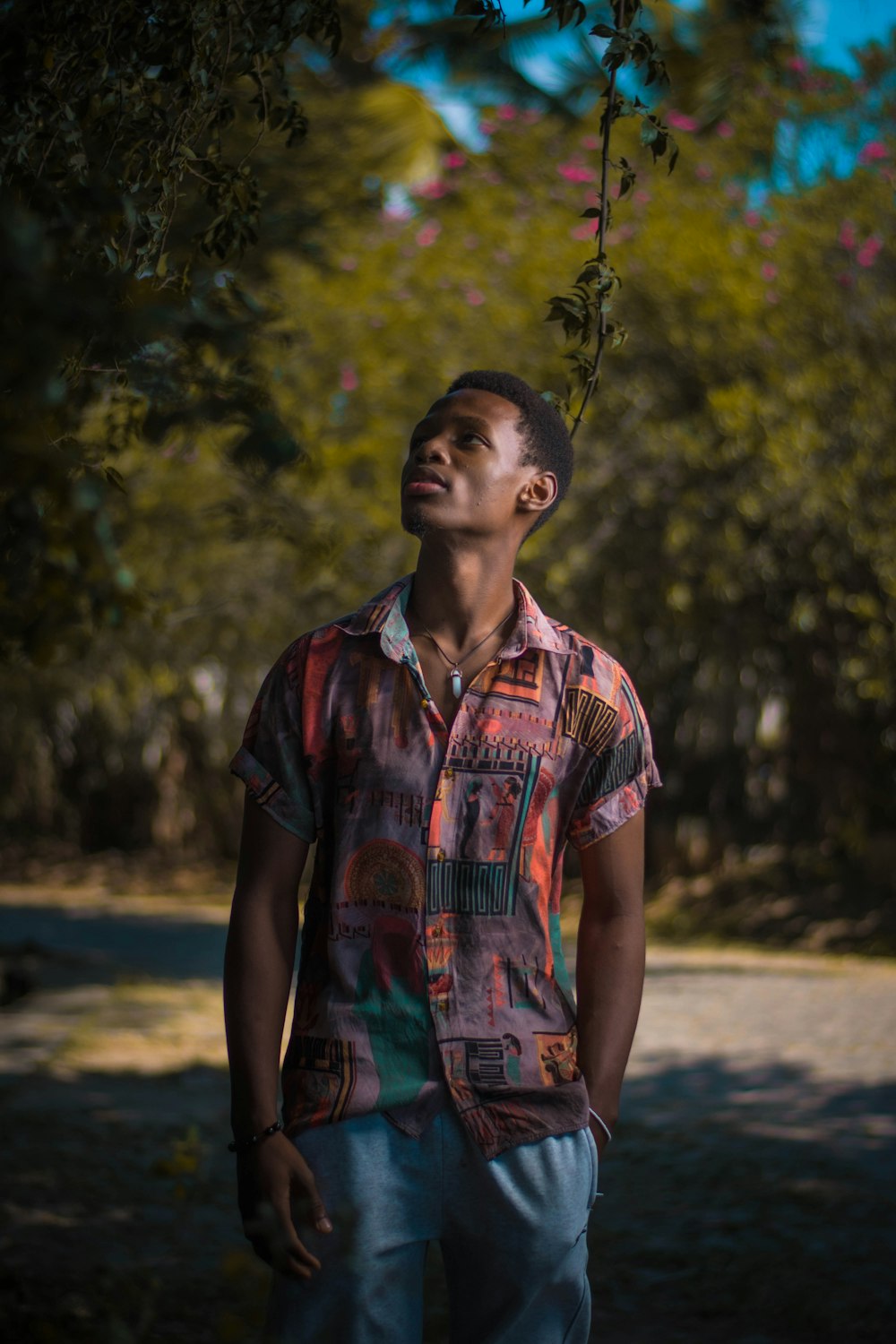 man in red and blue button up shirt standing on road during daytime