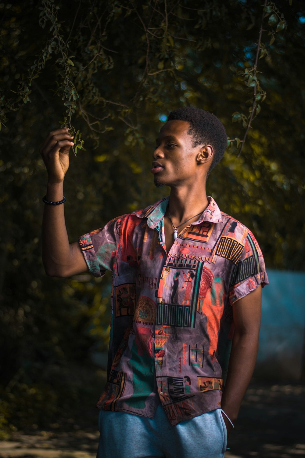 man in blue and red button up shirt standing and holding his face