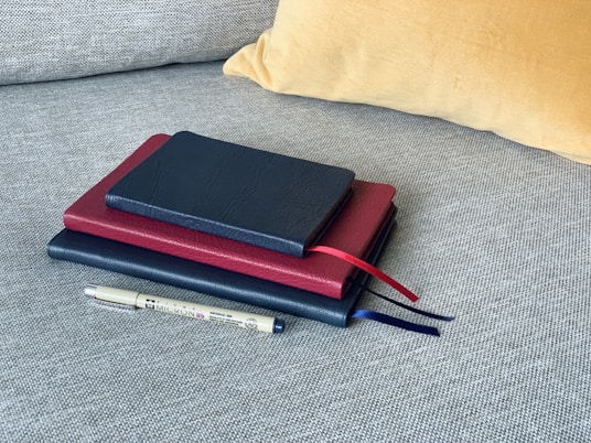 red and black tablet computer case on gray textile