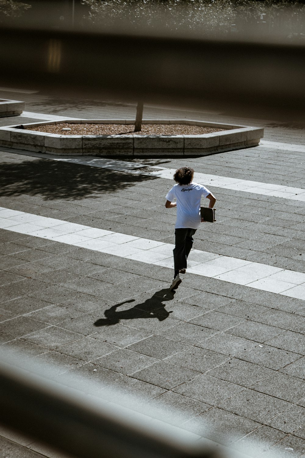 man in white long sleeve shirt and black pants walking on sidewalk during daytime