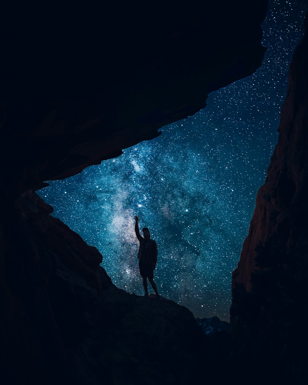 person in black long sleeve shirt standing on rock formation