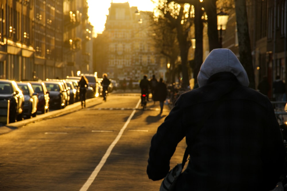 person in black jacket walking on pedestrian lane during daytime