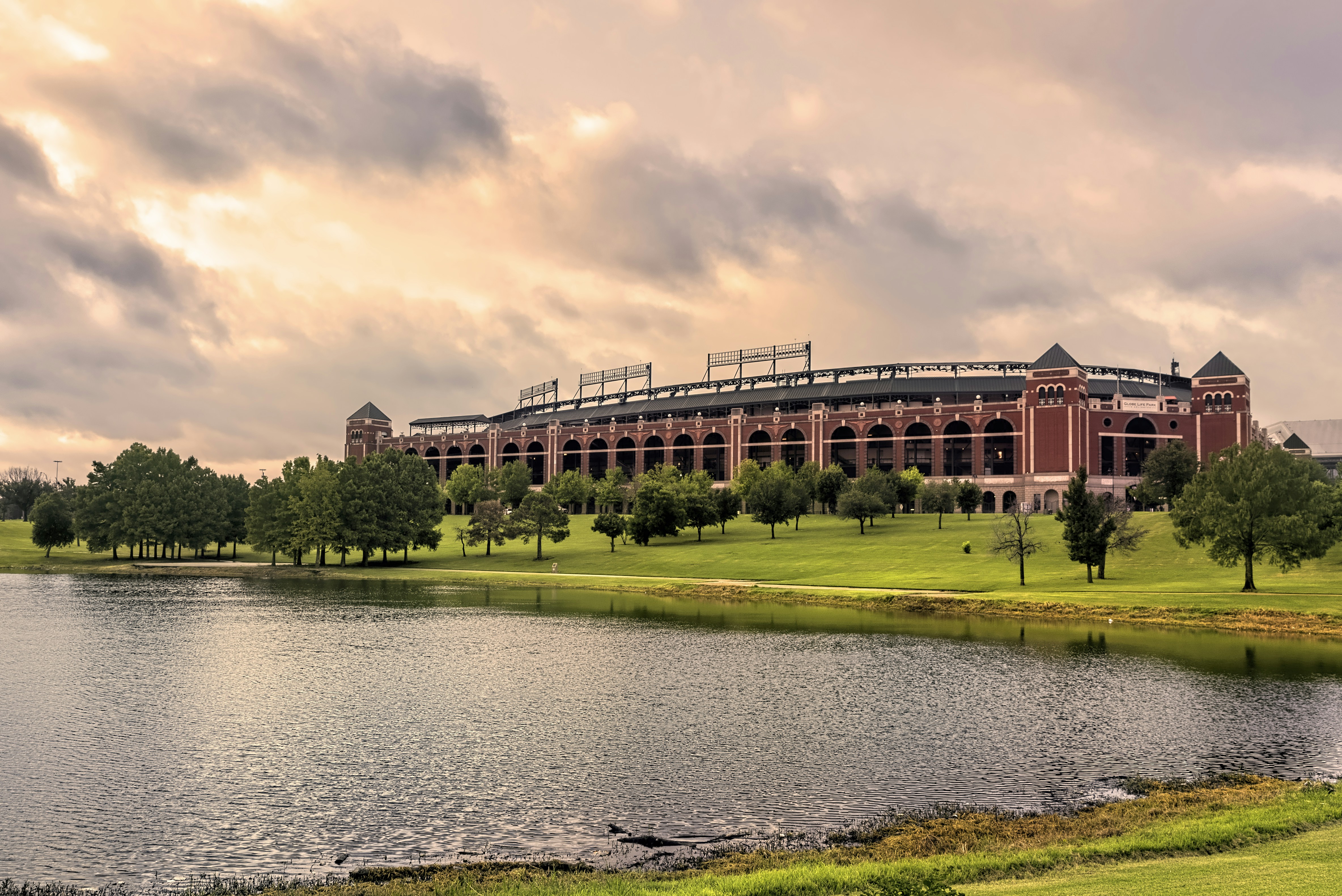 brown concrete building near river under cloudy sky during daytime