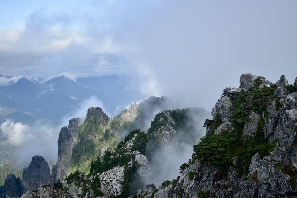 montagne verte et grise sous des nuages blancs pendant la journée