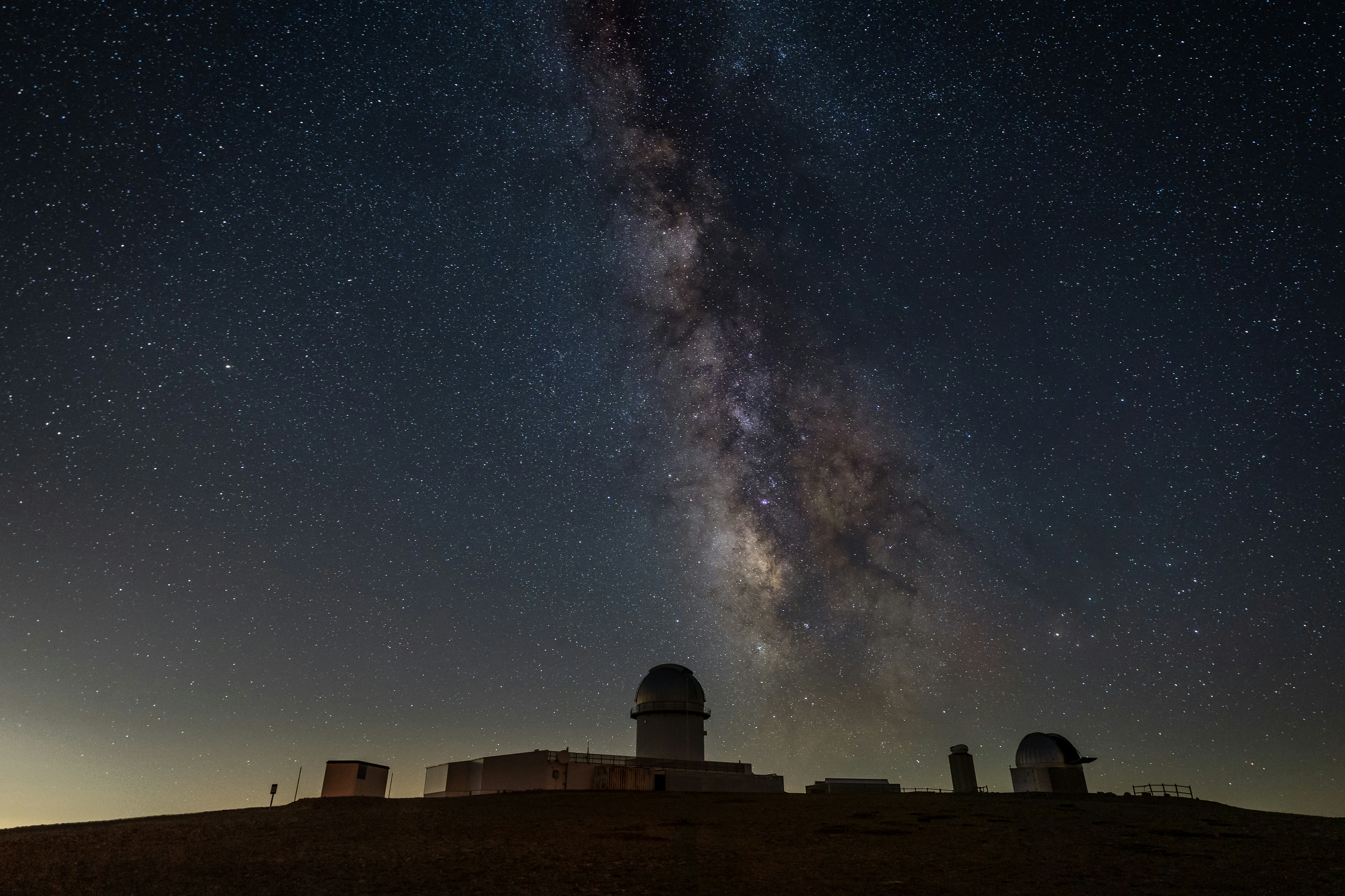 夜の青空に浮かぶ茶色と黒の家