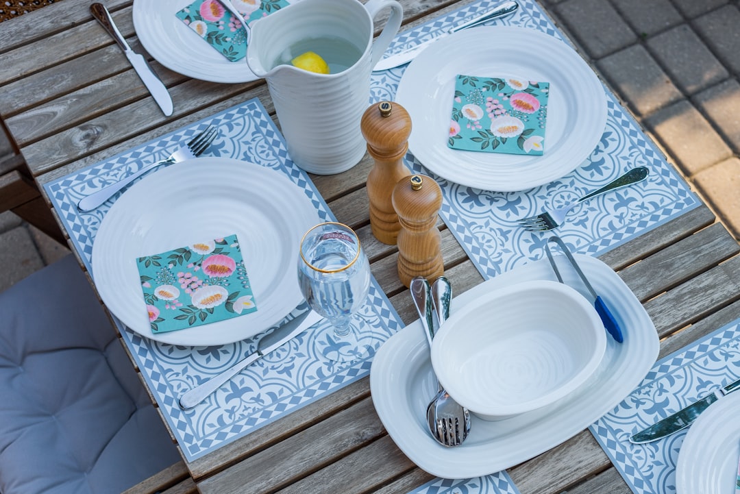 white ceramic plate beside clear drinking glass on table