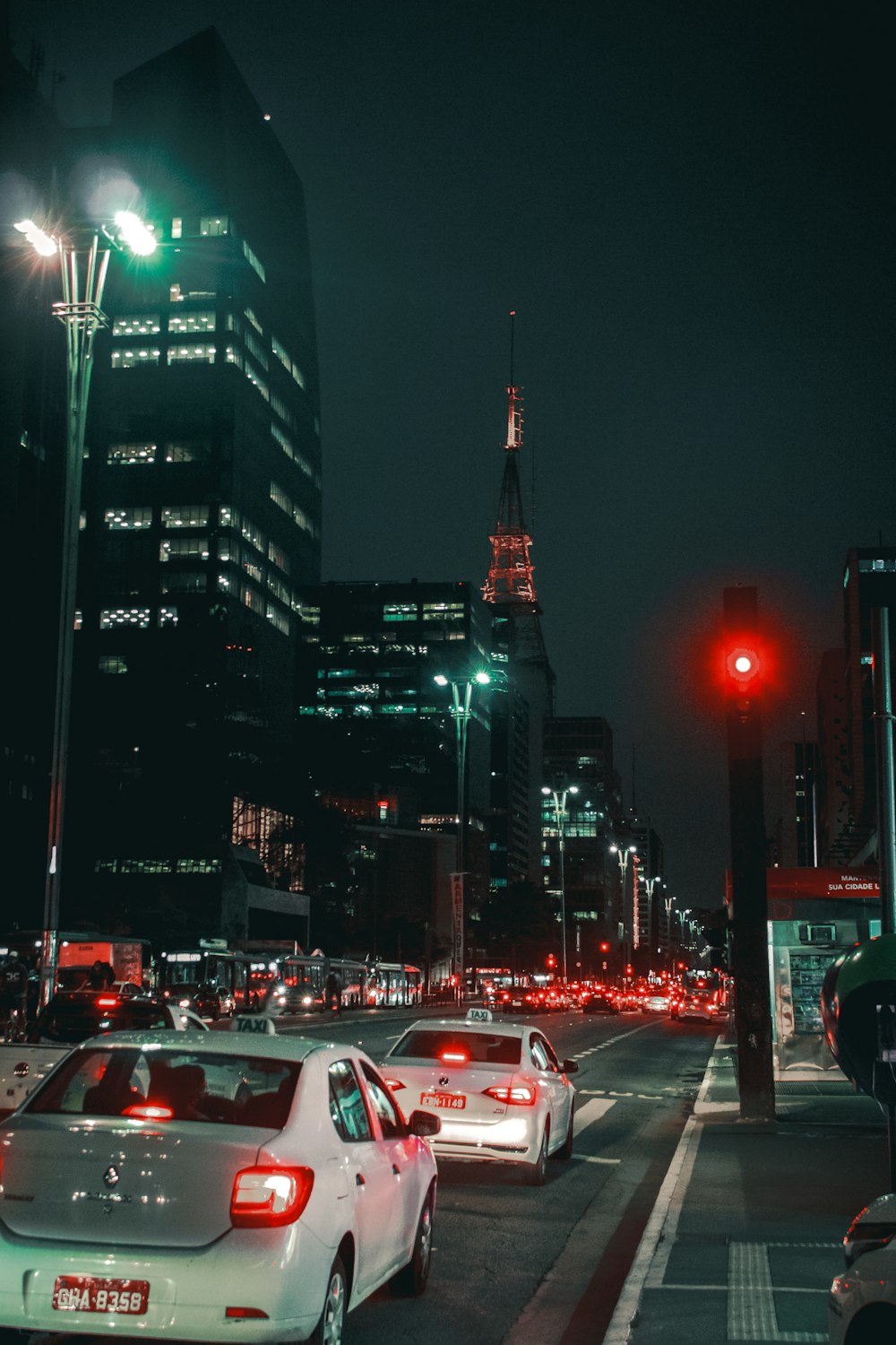 cars on road near high rise buildings during nighttime