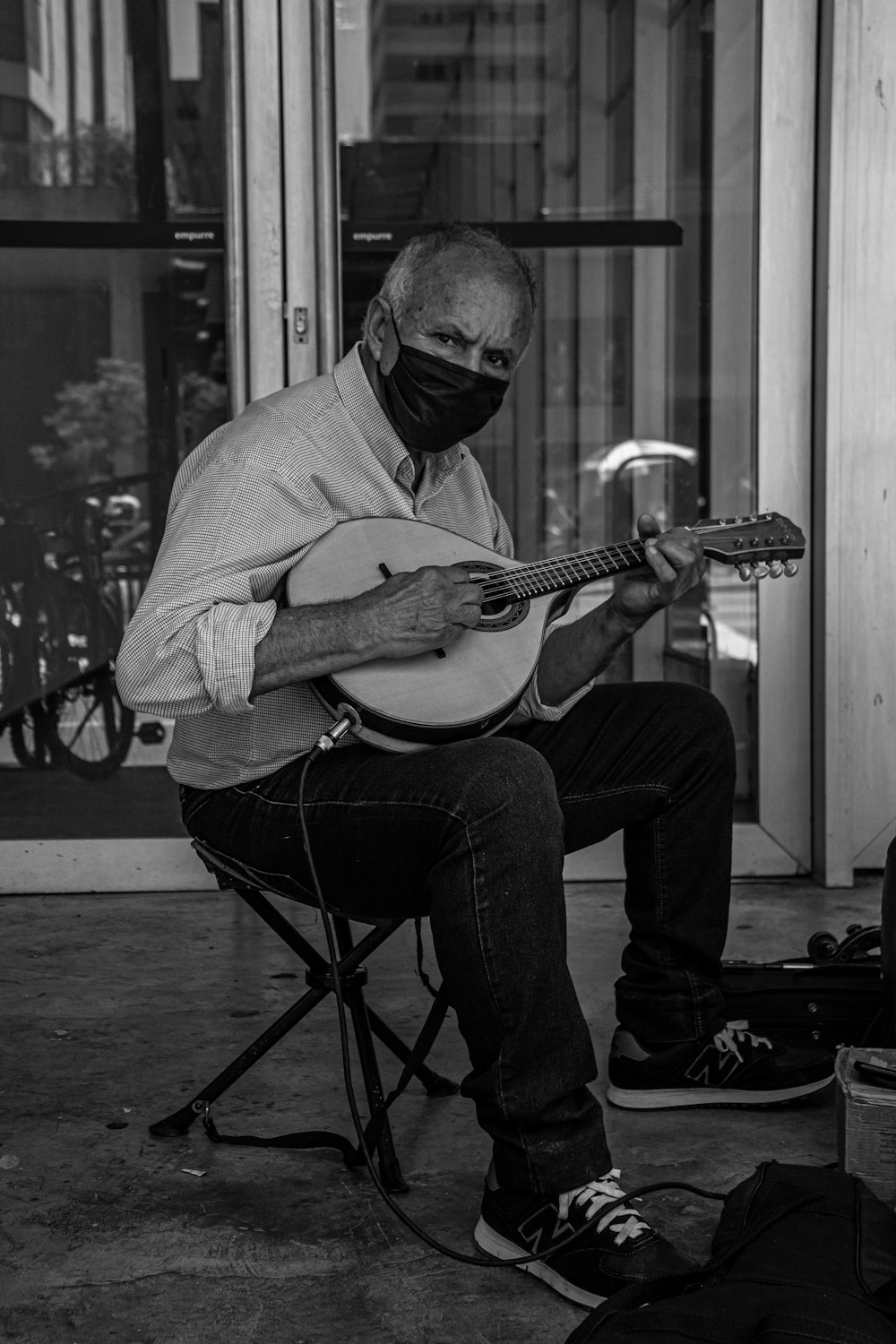 a man sitting on a chair while playing a guitar