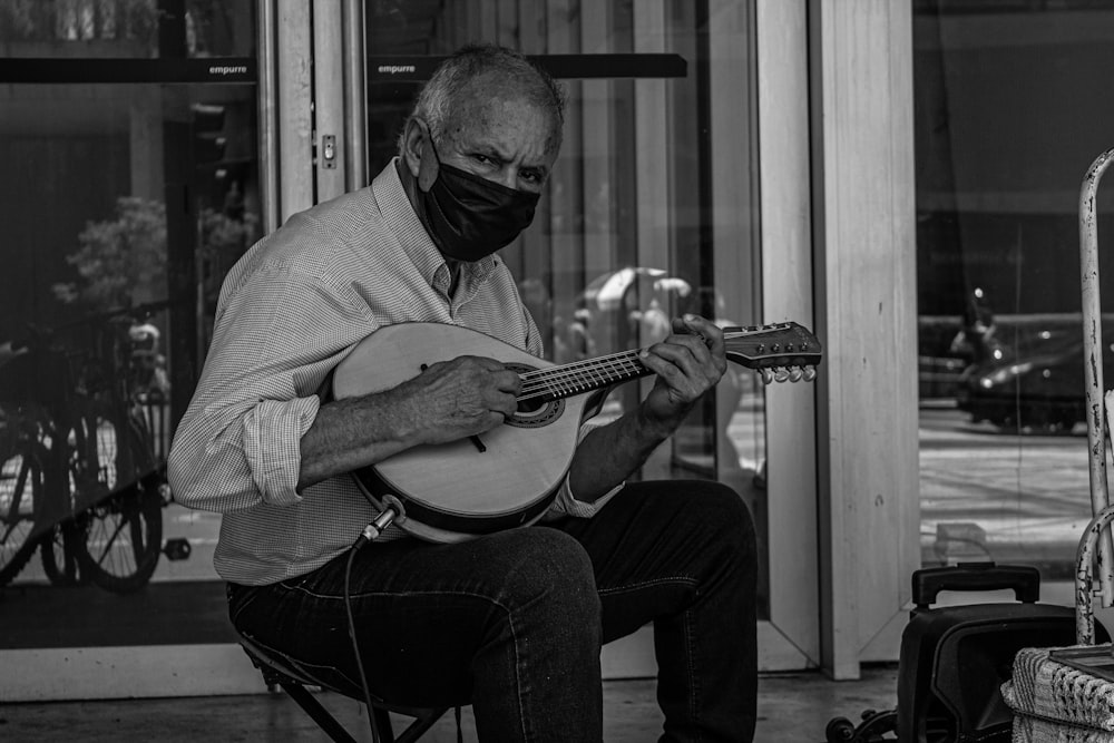 a man wearing a face mask playing a guitar