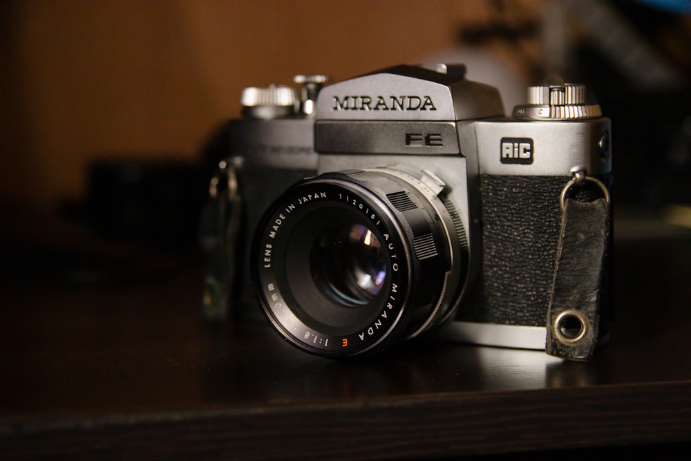 black and silver nikon dslr camera on brown wooden table