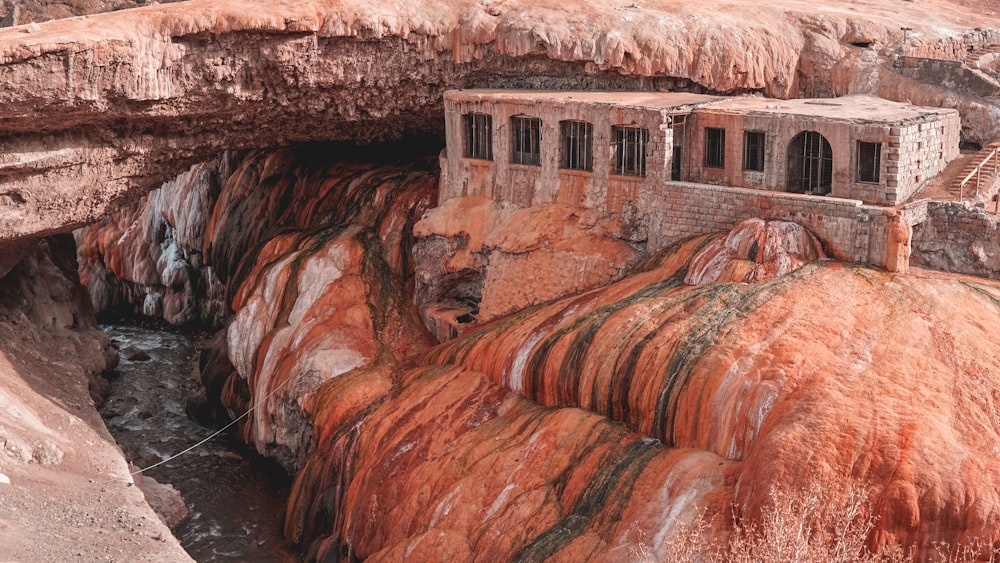 Formazione rocciosa marrone vicino allo specchio d'acqua durante il giorno