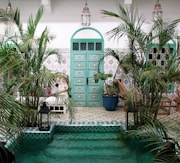 a pool with a green door surrounded by palm trees