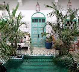a pool with a green door surrounded by palm trees