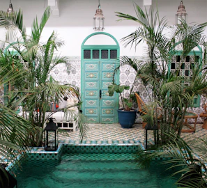 A sunlit Moroccan riad courtyard with vibrant tiles and lush greenery inviting travelers to relax.