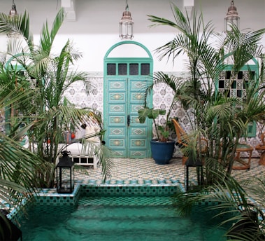 a pool with a green door surrounded by palm trees